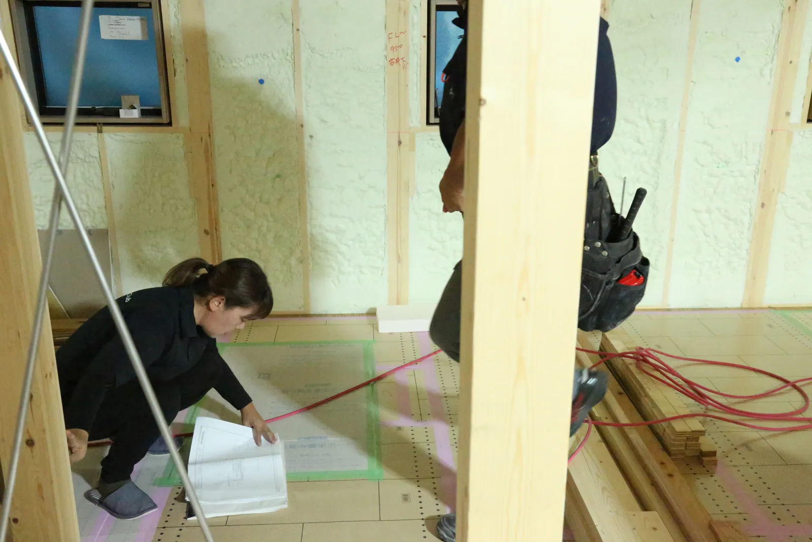 図面を見ながら現場で間取りや納まりを確認する様子